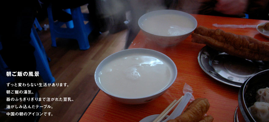 朝ご飯の風景：ずっと変わらない生活があります。朝ご飯の湯気、器のふちぎりぎりまで注がれた豆乳、油がしみ込んだテーブル。中国の朝のアイコンです。